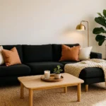 Stylish living room with black sofa decorated with cream cushions, jute rug, brass lamp, and fiddle-leaf fig plant