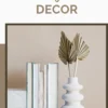 Minimalist bedroom decor with beige wall, white ceramic vase, dried palm leaves, and books.