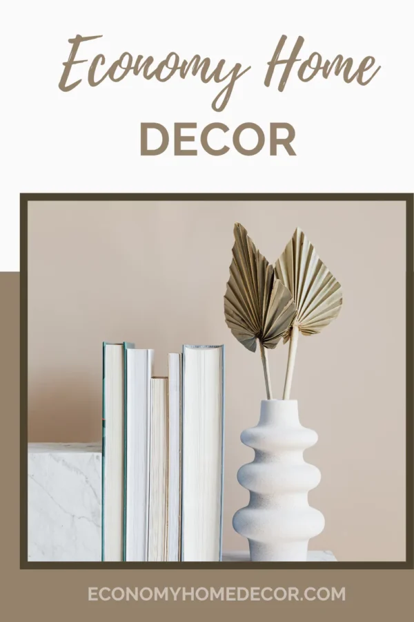 Minimalist bedroom decor with beige wall, white ceramic vase, dried palm leaves, and books.