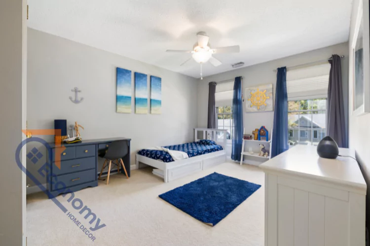A kid's or guest bedroom with a nautical theme, featuring a gray and white color scheme with pops of bright blue decor and bedding.