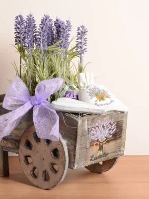 Rustic wooden wagon decor filled with faux lavender and two white lavender sachets, accented with a purple bow.