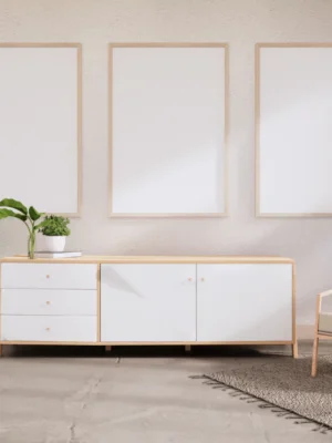 Three natural wood picture frames arranged on white wall above modern credenza