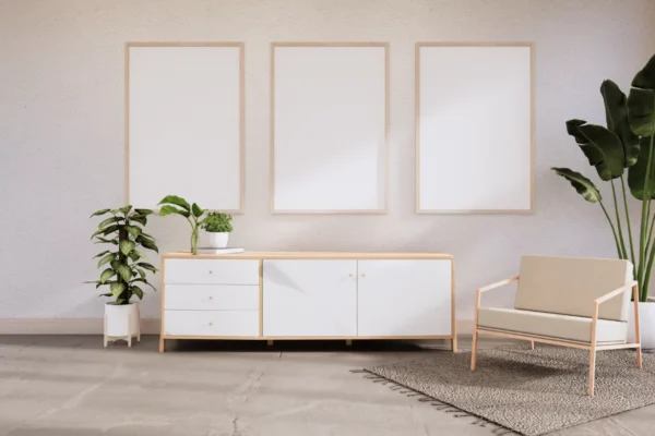 Three natural wood picture frames arranged on white wall above modern credenza
