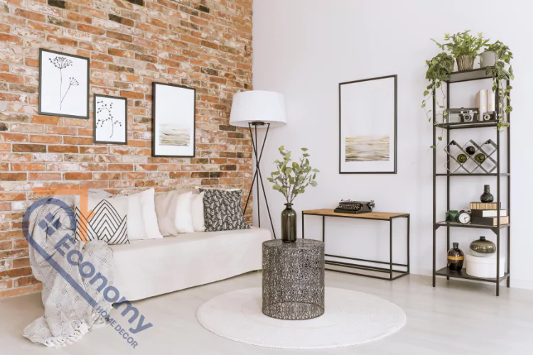A modern living room with a red brick accent wall decorated with framed wall art, a white sofa, and a black floor lamp.