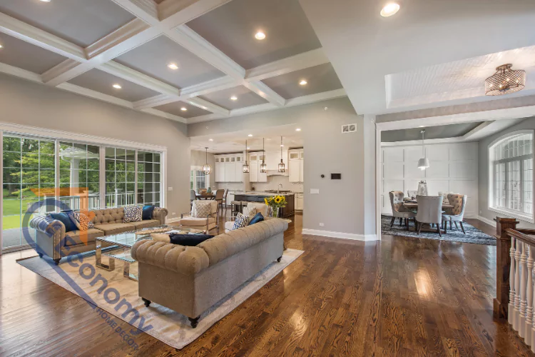 A spacious, open-concept living room with elegant furniture and dark hardwood floors, leading to a formal dining room and a modern kitchen.