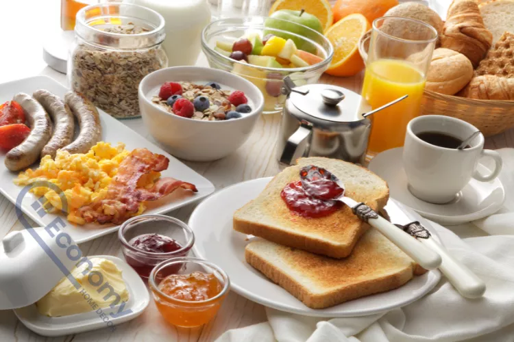 A close-up view of a complete breakfast table setting with a full, savory, and sweet spread.