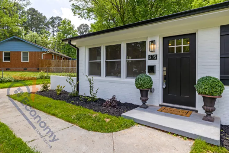 A bright, coastal-inspired Front Entry Decorating Idea with a tall palm tree next to a white door with full-length glass panels.