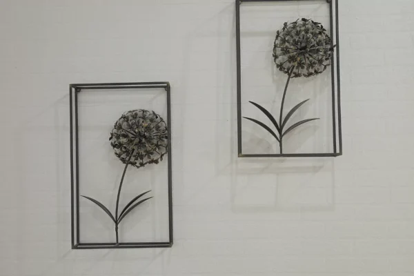 Set of two industrial chic metal dandelion wall art pieces in black rectangular frames against a white textured wall.