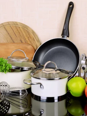 Modern Kitchen Set Complete kitchen set featuring white saucepans with glass lids, a large black frying pan, wooden cutting boards, and assorted stainless steel utensils.
