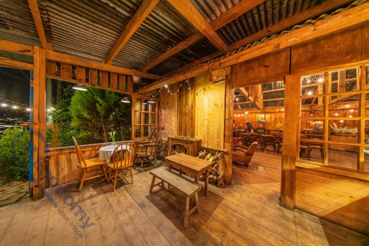 A rustic covered porch or patio demonstrating Mountain Lodge Decorating Ideas, with warm wood walls, floors, and ceiling beams.