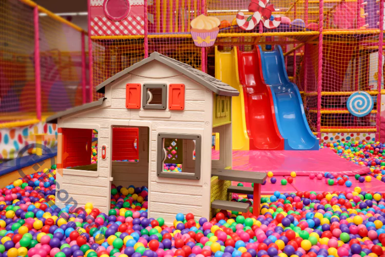 An image demonstrating "Playhouse Decorating Ideas" in an indoor playground setting, featuring a small house structure in a large ball pit.