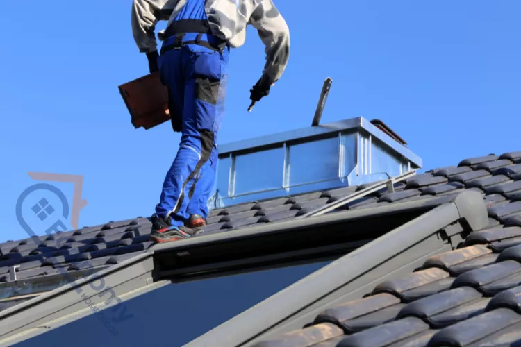 A roofer wearing blue overalls and a safety harness installing a skylight or working on a new ventilation unit as part of Professional Roofing Solutions.