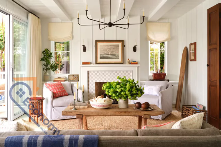 A cozy living room featuring rustic cottage decor, with shiplap walls, exposed ceiling beams, and a natural jute area rug.