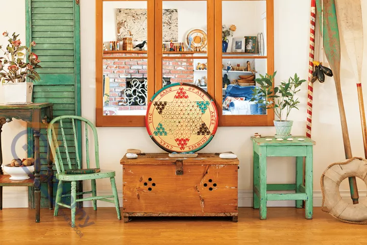 A creative display of upcycled decor ideas, featuring a vintage wooden chest used as a coffee table and an old green chair.