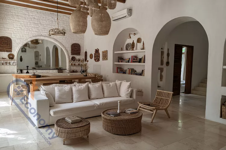 A bright, open-plan bonus room with a Mediterranean or bohemian style, featuring white brick walls and woven light fixtures.