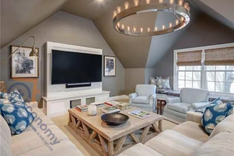 A cozy attic bonus room converted into a living area with sloped ceilings and a large circular industrial chandelier.