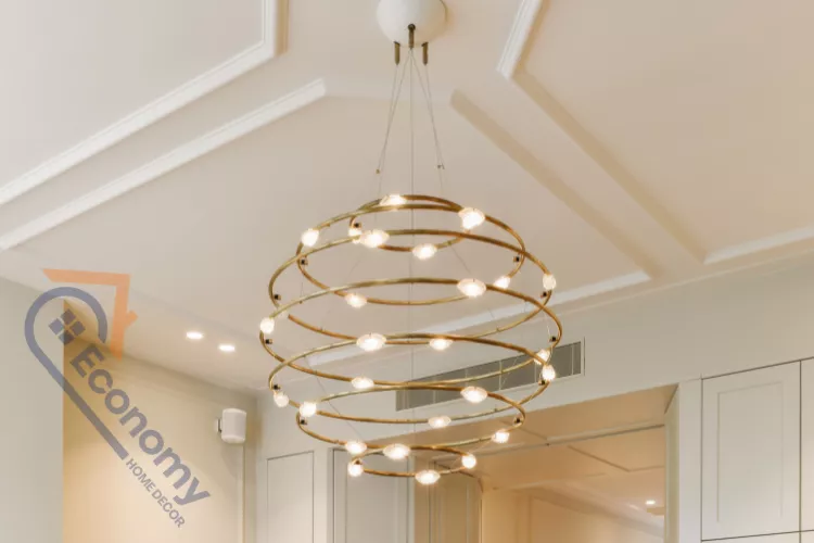 A modern, gold-toned spherical chandelier with internal lights, serving as a striking hanging ceiling decoration idea.