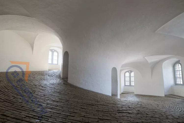 A contemporary entryway showcasing how to decorate a curved wall using built-in recessed shelving and a long bench.