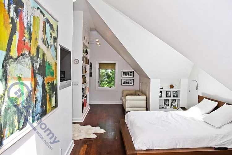 A contemporary attic bedroom maximizing space with a dramatic slanted wall, white paint, and dark hardwood floors.