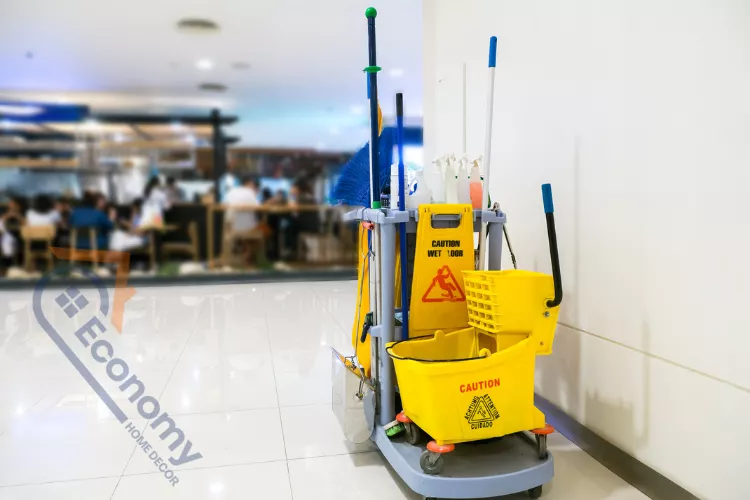 Commercial cleaning cart with mop, bucket, and cleaning supplies in a bright indoor facility, representing professional commercial cleaners.