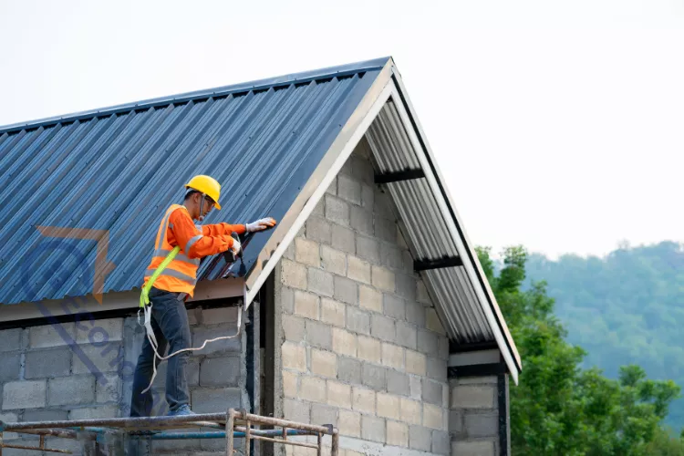 Professional roofer installing metal sheets on a new home roof as part of a Vanity Roofing project.
