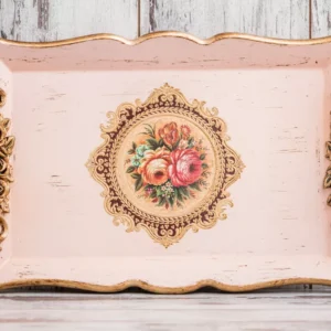Ornate vintage shabby chic serving tray in distressed pink and cream with gold trim and a central floral bouquet decal.