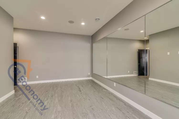 A bright and modern basement apartment decorating idea featuring a white sofa and a gallery wall.