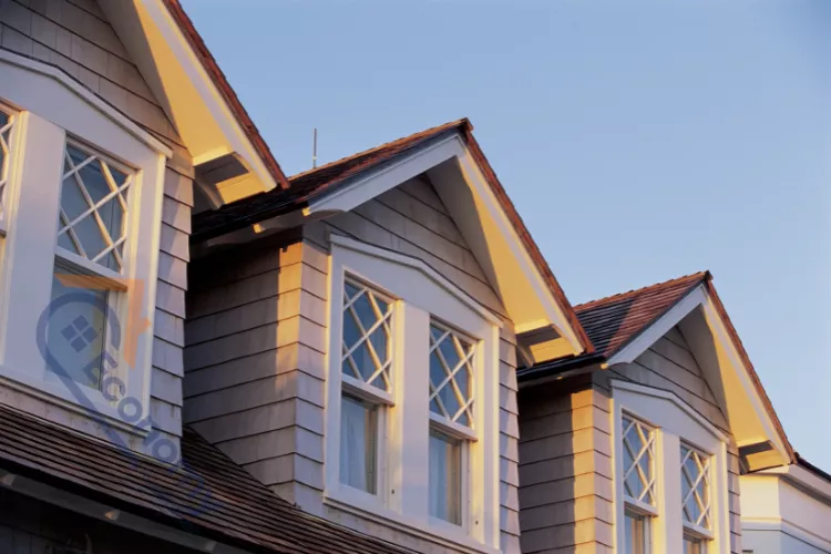 A row of traditional dormer exterior window decorations on a home, featuring classic white trim and diamond-paned upper sashes.