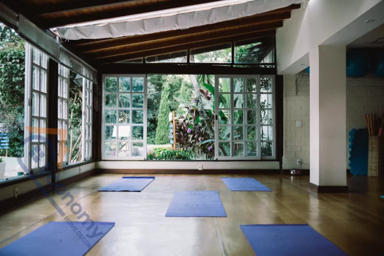 A cozy home yoga studio decor setting with layered rugs, patterned textiles, and a wicker basket for storage.
