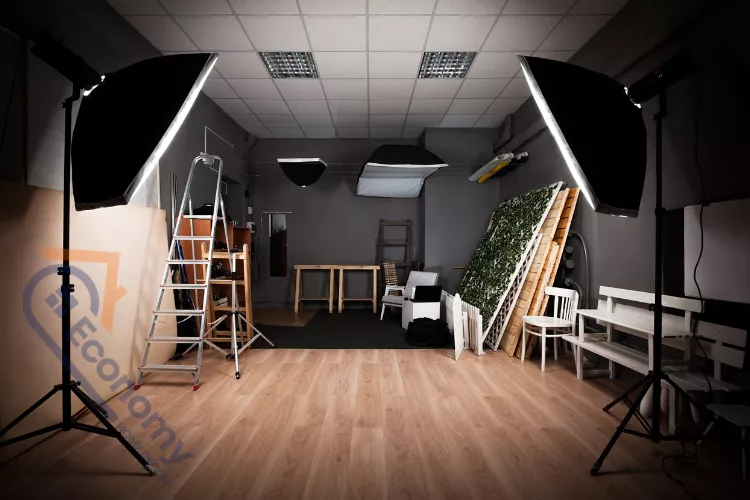 A contemporary studio flat living area showing how to decorate a sofa with vibrant cushions and a gallery wall.