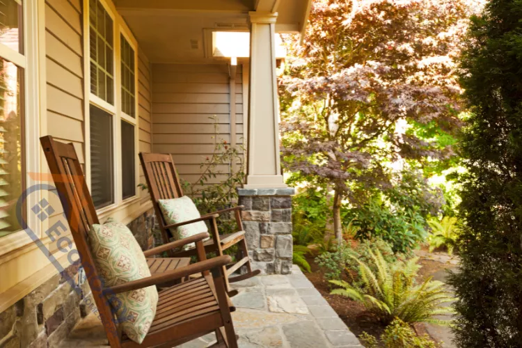 A cute small front porch decorating idea for fall featuring stacked pumpkins and a bright yellow-gold wreath.