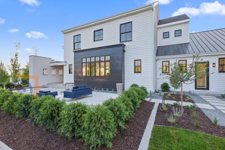 A stunning modern farmhouse exterior featuring striking black-framed windows against white siding.